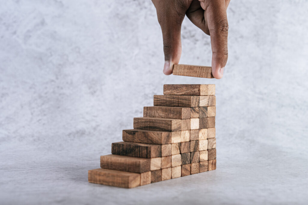 A man stacking wooden blocks on each other.