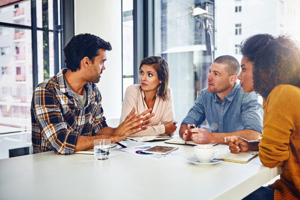 Four people in the office interacting with each other.