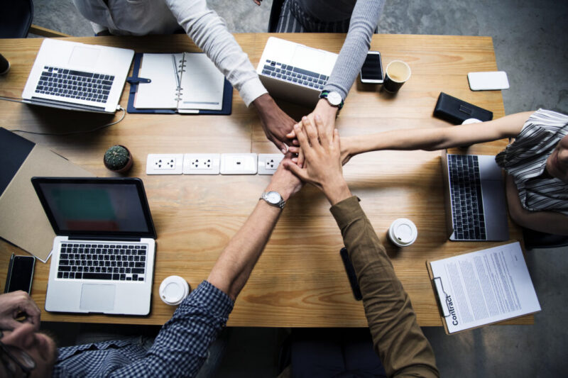 group of people stacking hands together.