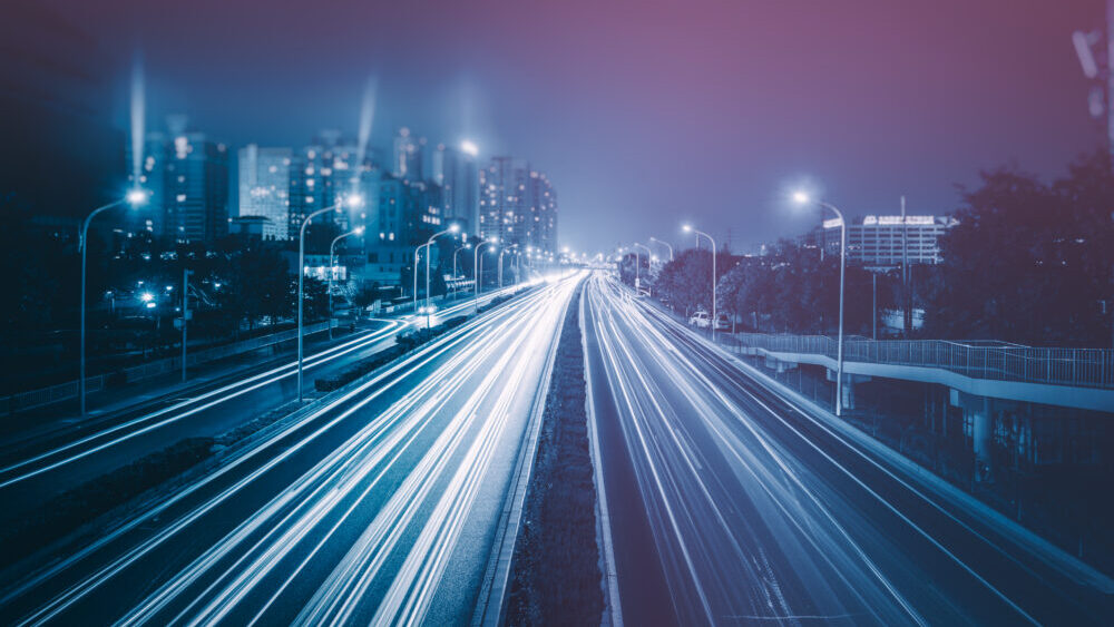 Blurred traffic light trails on road.