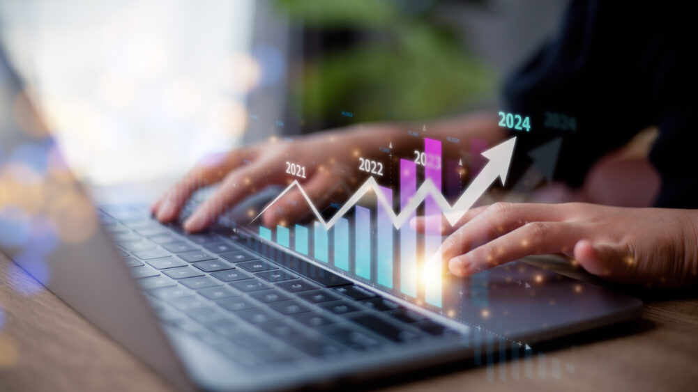 Business woman typing in the laptop showing the progress in an upward motion.