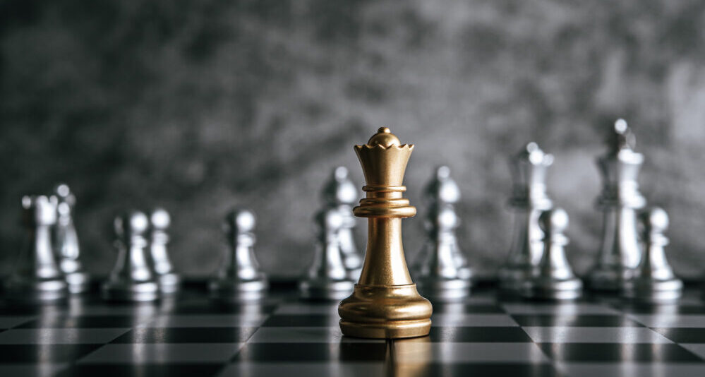 Gold and Silver Chess pieces on chess board game